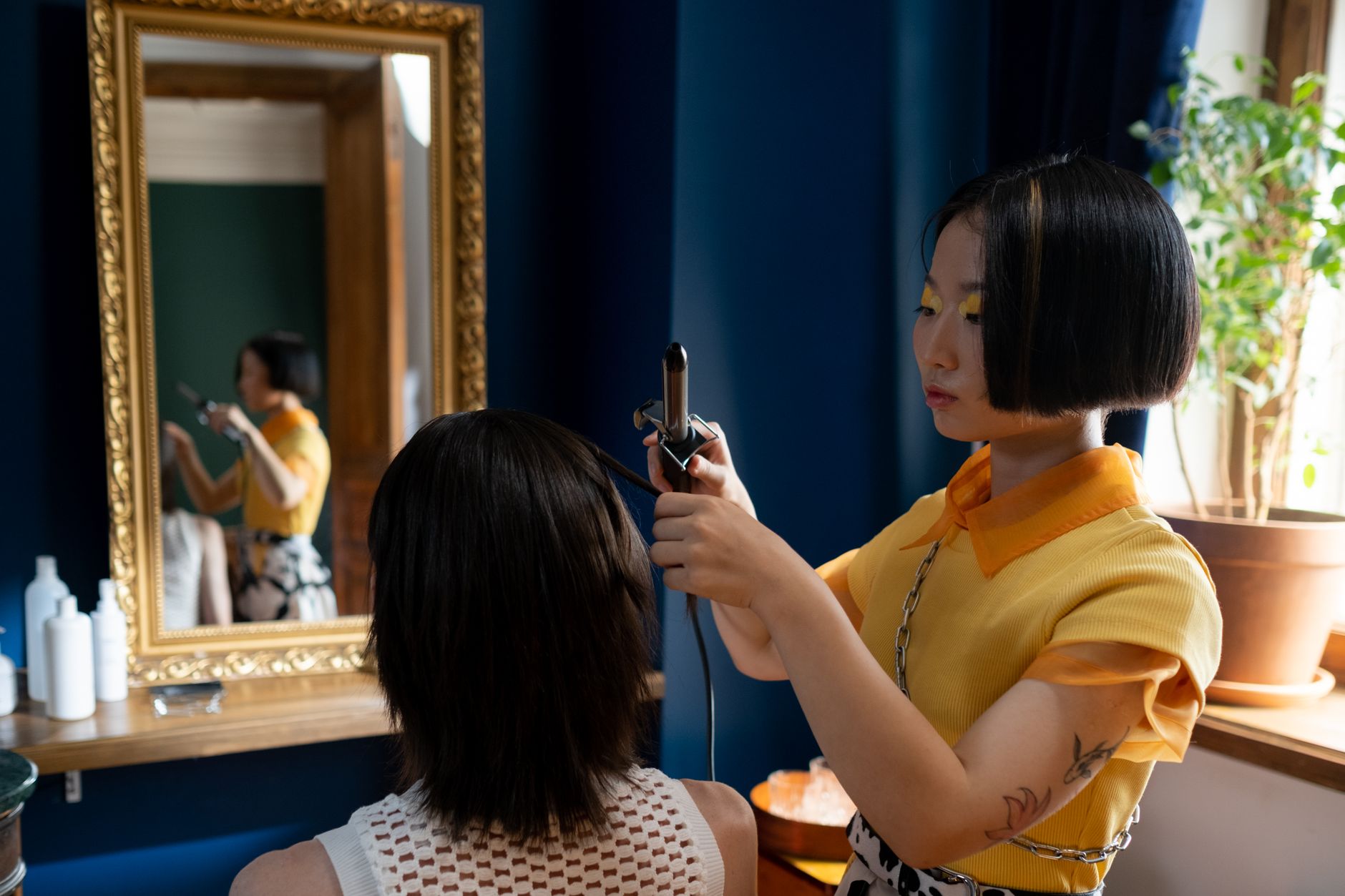 A stylist finishing a client's hair at Lumen Studio